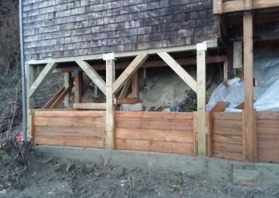 Close-up of foundation repair under a house with tools.
